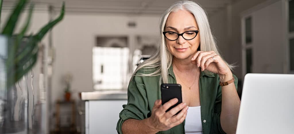 mature woman connecting her hearing aids to her phone